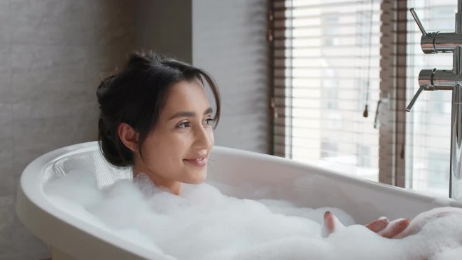 Woman taking bath in bathtub at bathroom, Stock Video