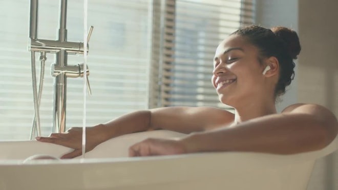 Young black woman preparing to take a bath in bathroom Stock Photo by  Prostock-studio