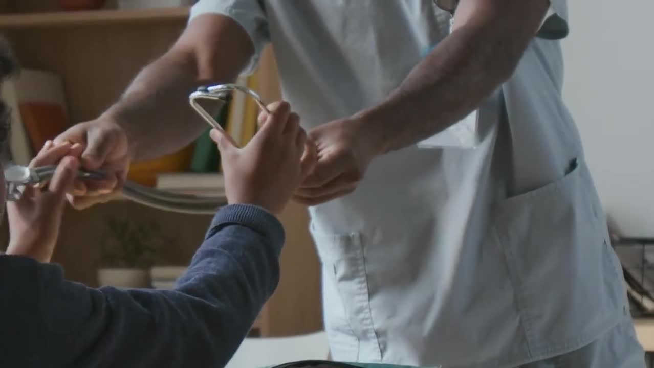 Doctor In Scrubs Demonstrating Stethoscope During Career Day