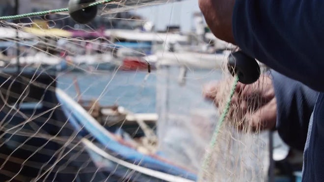 Fisherman Is Repairing Fishnets On Boat - Stock Video