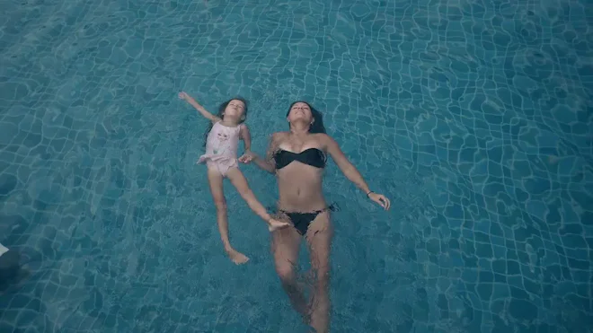 Woman Bikini Kid Swimsuit Lie Swimming - Stock Video