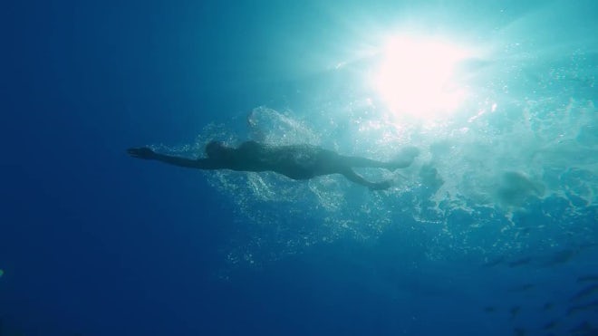 person swimming underwater in ocean