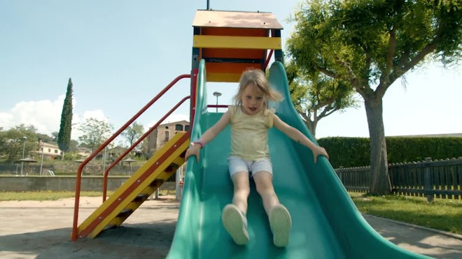 A little girl is sliding down a children, Stock Video