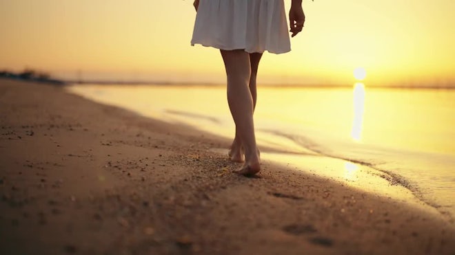 New Beginning: A woman walking alongside the beach
