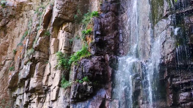 Small waterfall with water splashing and tumbling over the rocks