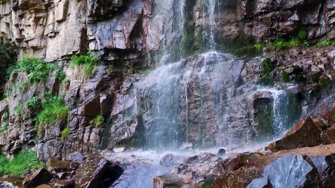 Small waterfall with water splashing and tumbling over the rocks