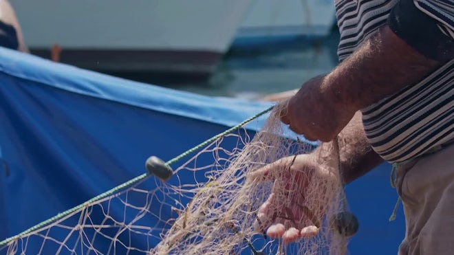 Fishermen At Work Cleaning Fishing Nets - Stock Video