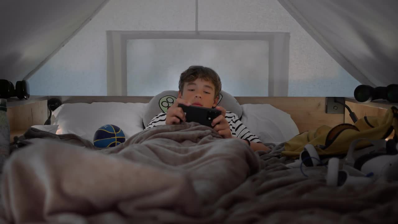 Teen Boy Playing Video Game In Bed by Magiclantern - Stock Video