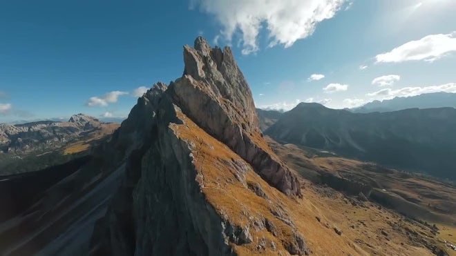 A drone flying near a rocky cliff face