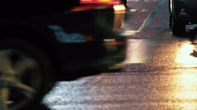 Night shot of pedestrians crossing road full of mopeds in busy