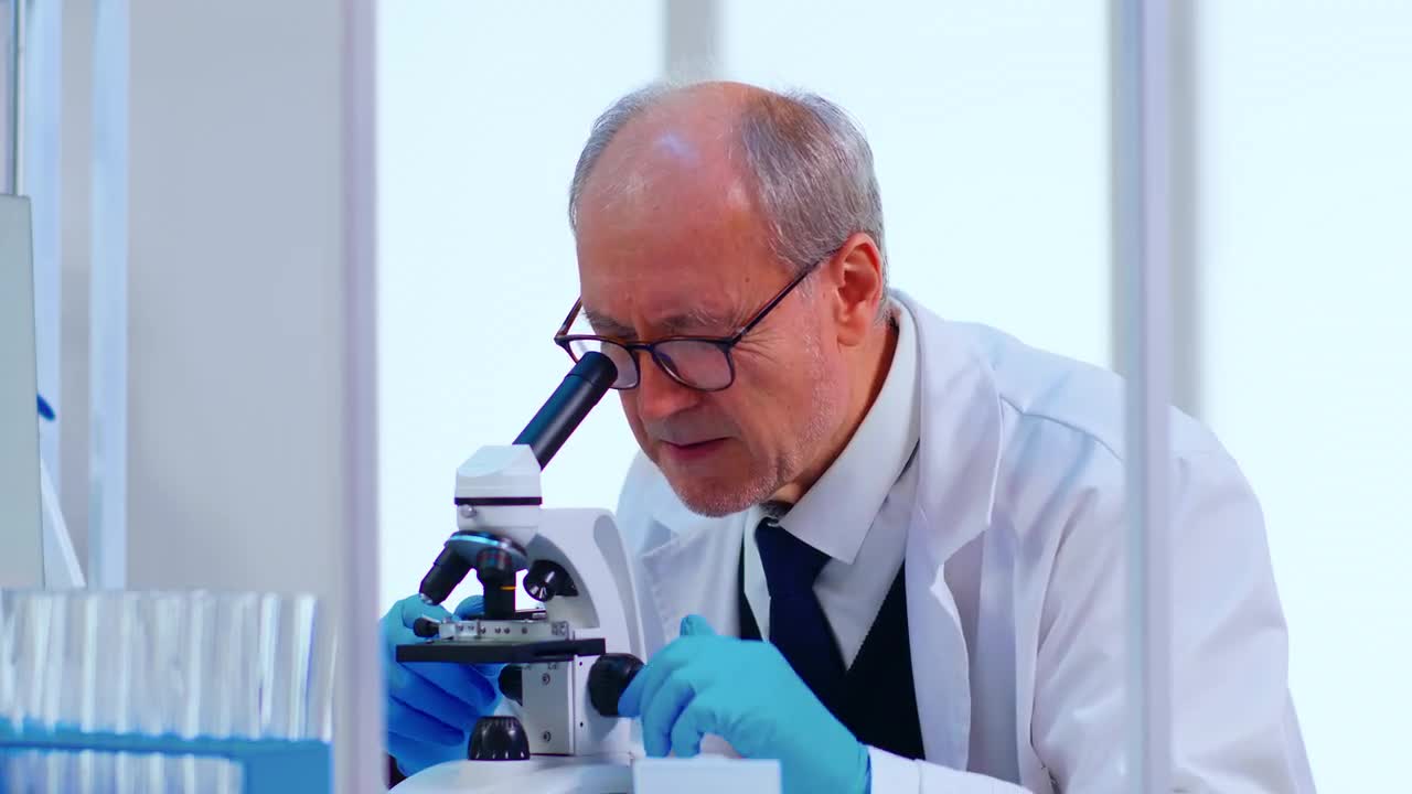 Senior Lab Technician Using Microscope Stock Video Motion Array
