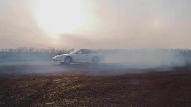 drift car drifting around a tire stack 4k night time