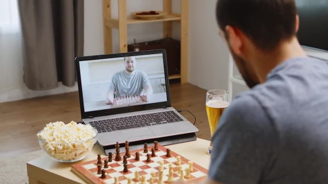 Man playing chess against computer Stock Photo