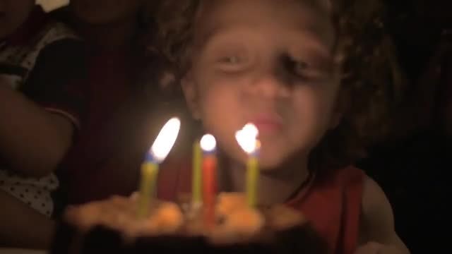 Child Blowing Out Candles: Stock Video