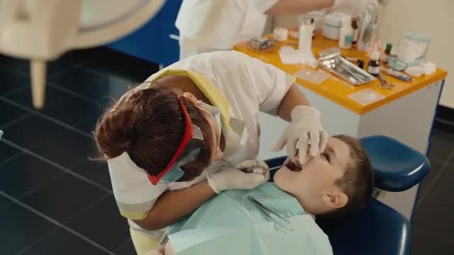 Dentist Examining A Young Boy: Stock Video