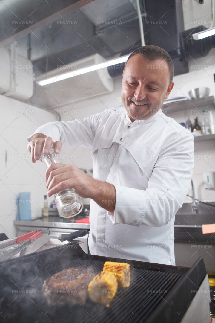 Chef Salting Grilled Meat: Stock Photos