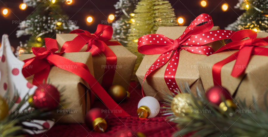 Premium Photo | Christmas gift and christmas little tree in santa's hat on  a background with bright lighting lights