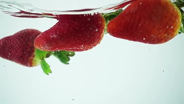 Fresh Strawberries Dropped Into Water: Stock Video