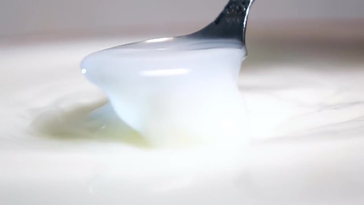 Scooping Up Milk With Spoon: Stock Video