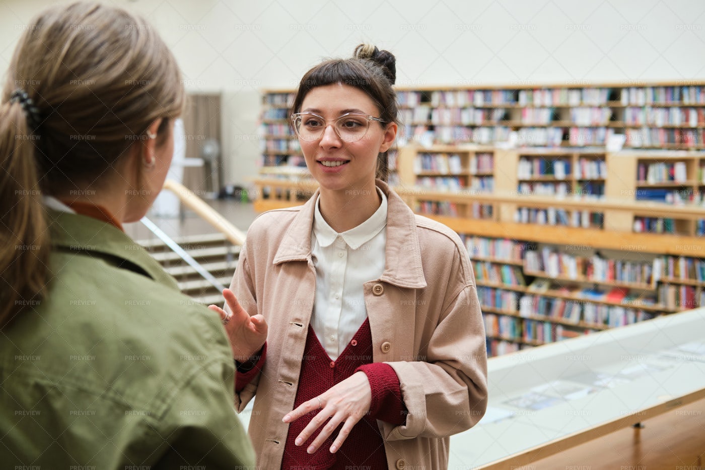 Friends Talking In The Library: Stock Photos