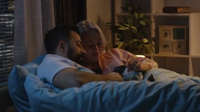Couple Using Phone In Bed: Stock Video