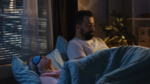 Partner Using Phone Before Bedtime: Stock Video