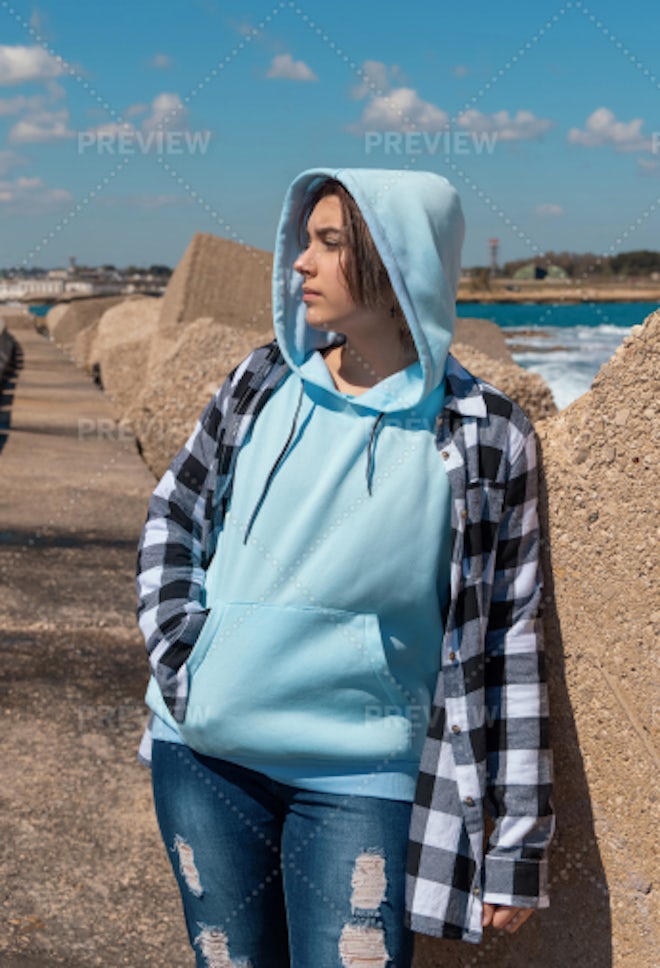 Blue haired Teenage girl in blue hoodie staying near graffiti wall with red water  bottle Stock Photo by katrinshine