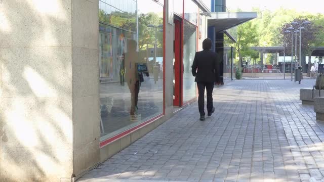 Businessman Walks On Commercial Street: Stock Video