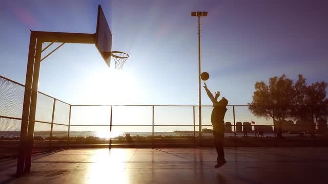 Man Playing Basketball At Sunset: Stock Video