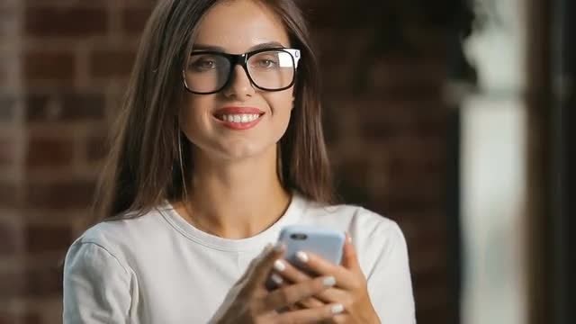 Smiling Woman Uses Smartphone: Stock Video