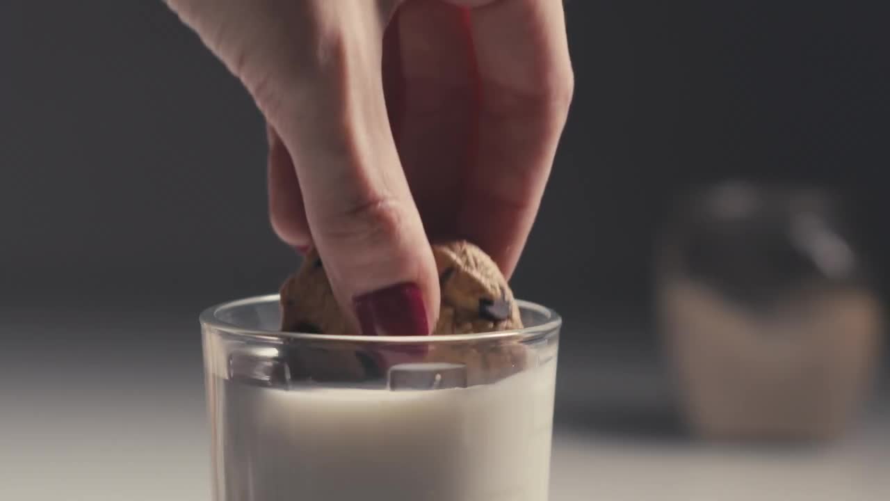 Dipping A Chocolate Chip Cookie In Milk Stock Video Motion Array