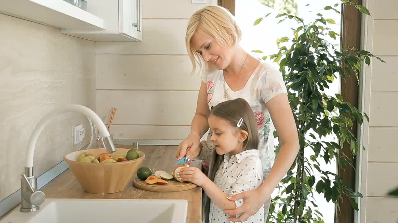 Mom Teaches Daughter To Cut An Apple Stock Video Motion Array