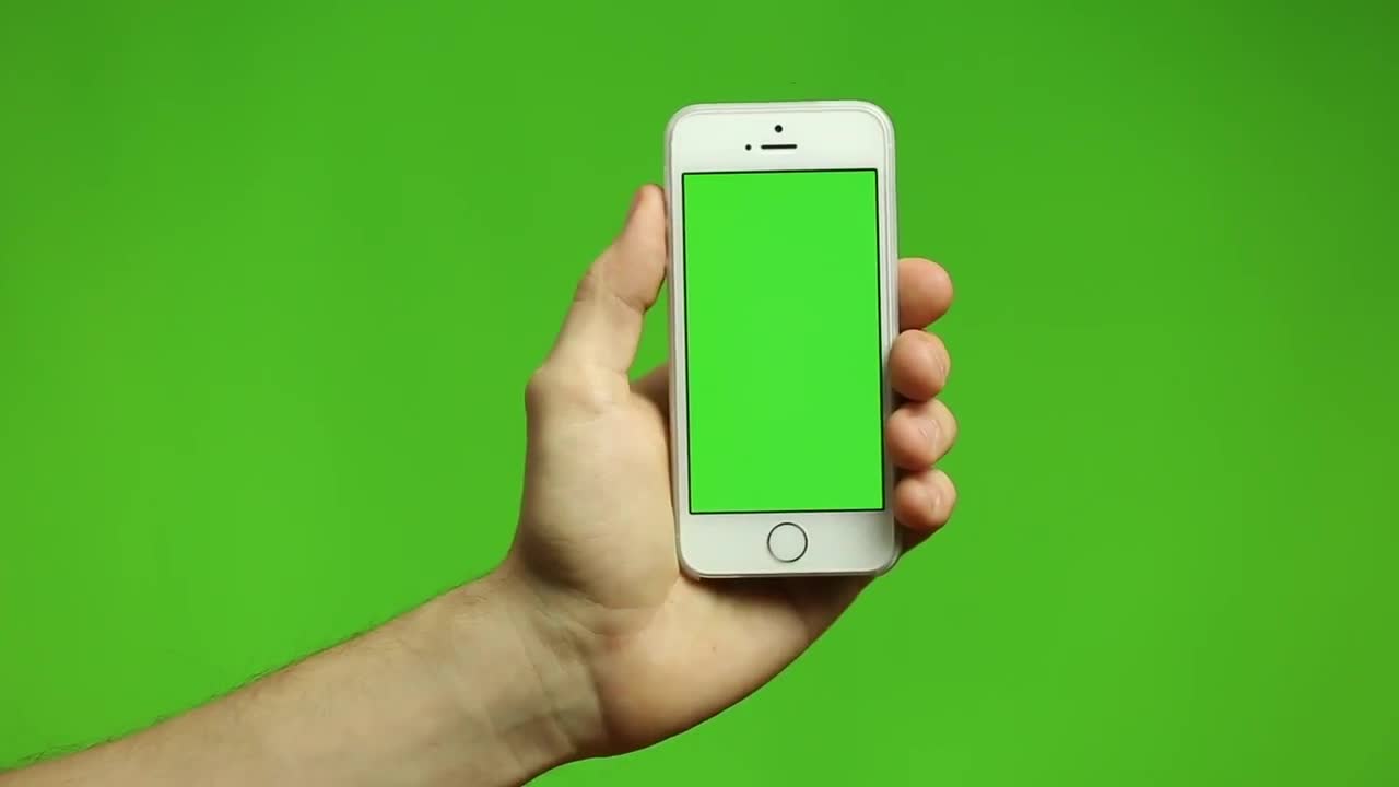 Рука с телефоном на зеленом фоне