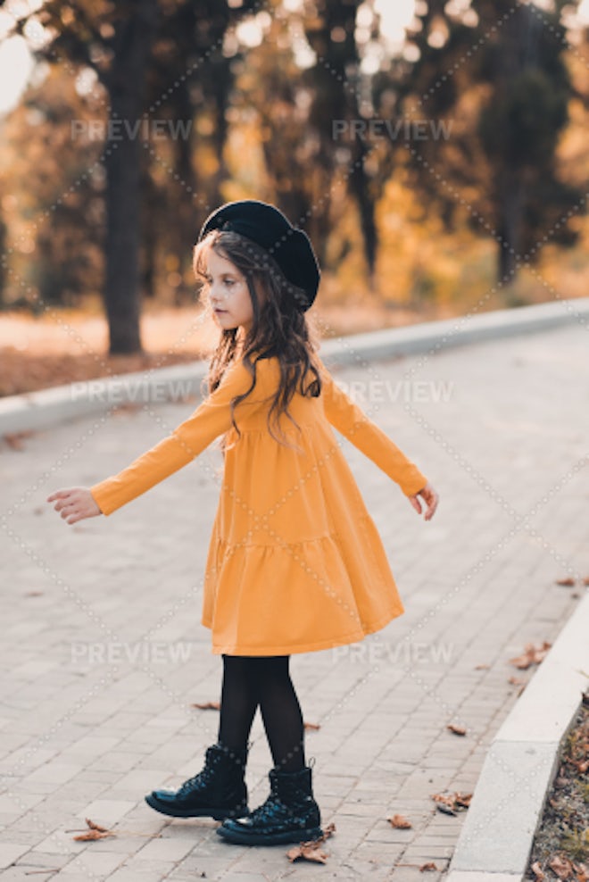 Pretty kid girl 4-5 year old wearing stylish autumn clothes in park.  Looking at camera. Fall season. Childhood. Stock Photo