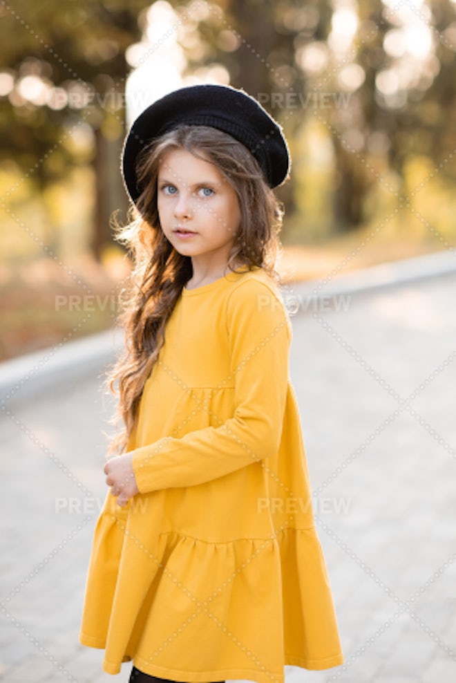 Pretty kid girl 4-5 year old wearing stylish autumn clothes in park.  Looking at camera. Fall season. Childhood. Stock Photo