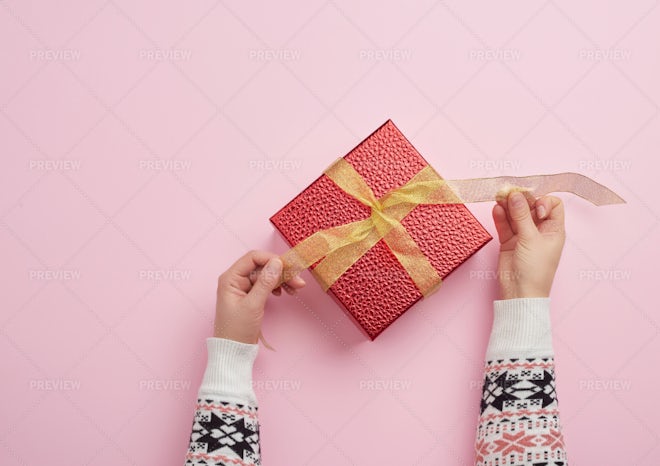 Female hand hold a box wrapped in red paper and tied with a red silk ribbon,  holiday Stock Photo by ndanko
