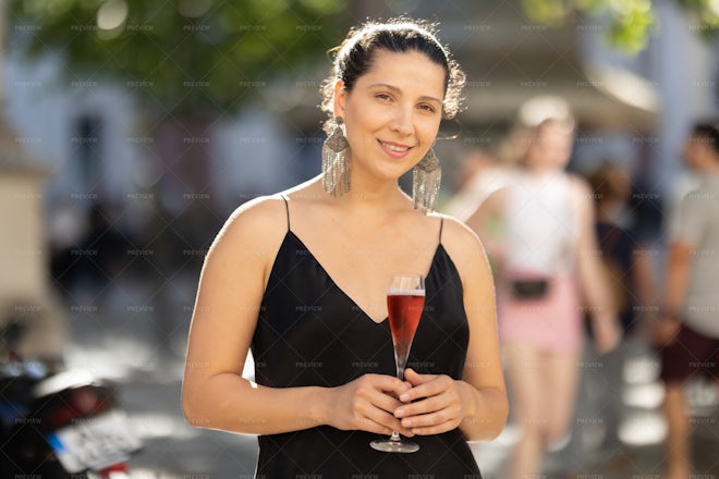 Businesswoman drinking from large wine glass with straw stock