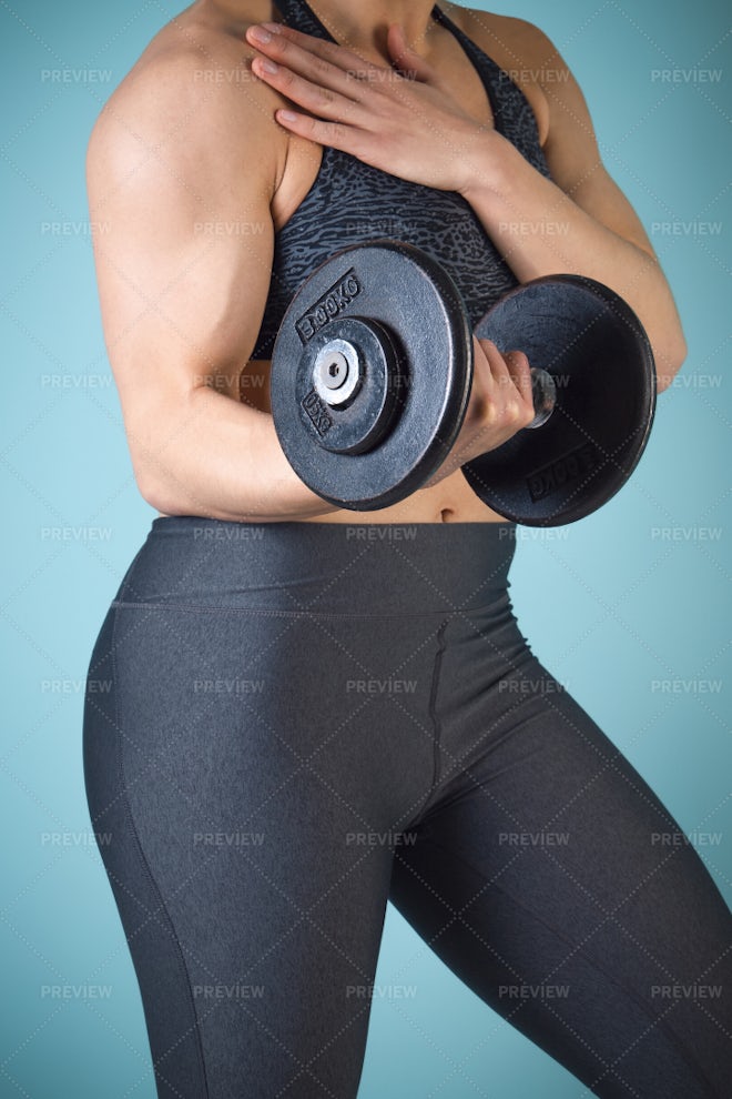 Fit strong woman lifting weights. Working out with dumbbells Stock Photo