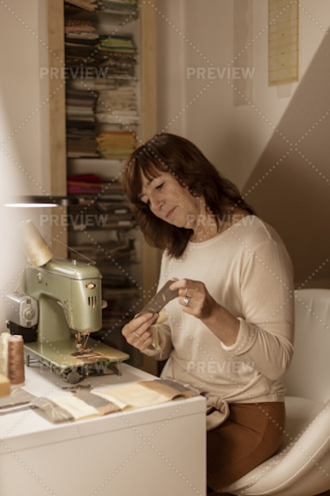 A Woman Tailor Works At Sewing Machine - Stock Photos