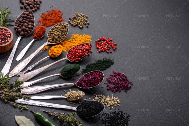 Spices in spoons on black background.