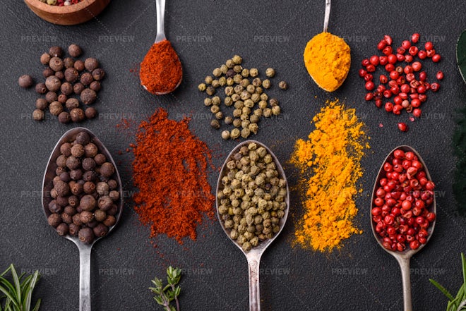 Spices in spoons on black background.