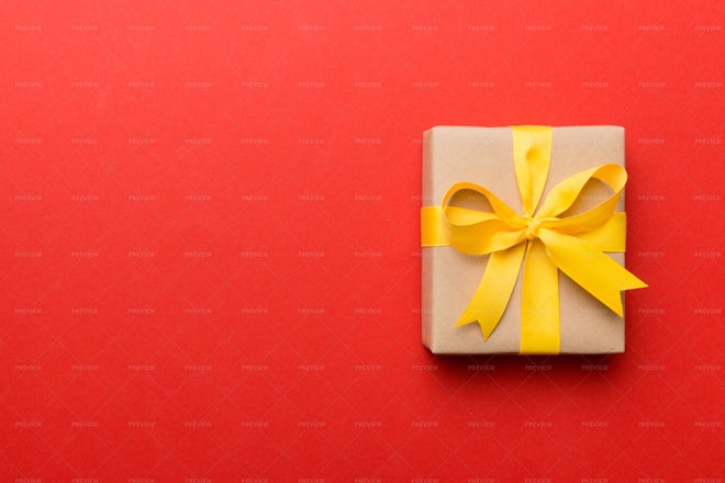 Red Gift Wrapping Ribbon Around A Box With A Yellow Tag Stock