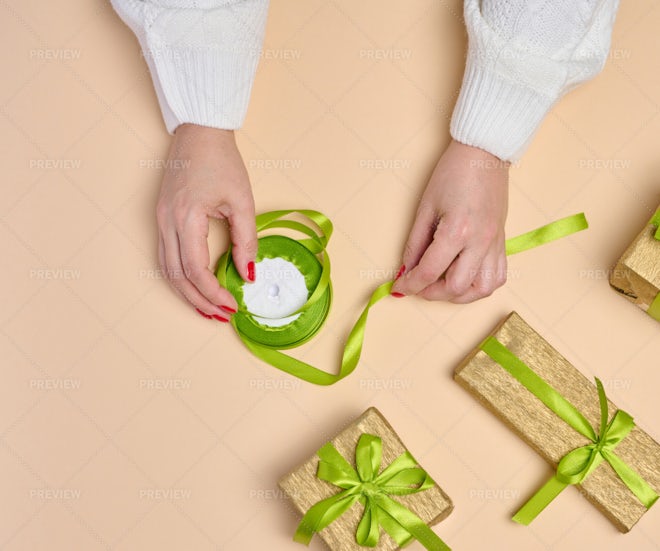 Female hand hold a box wrapped in red paper and tied with a red silk ribbon,  holiday Stock Photo by ndanko