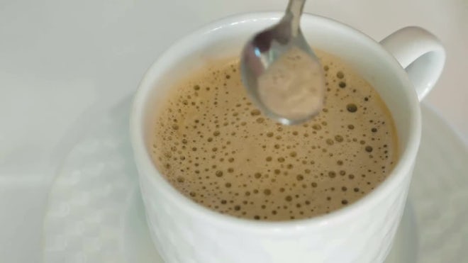 Stir the hot coffee in a cup with a spoo, Stock Video