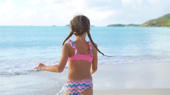Attractive slim teenager girl in bikini runs along the beach Stock Photo