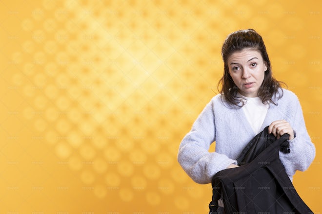 Portrait Of Woman Rummaging Through Backpack Studio Photoshoot Stock