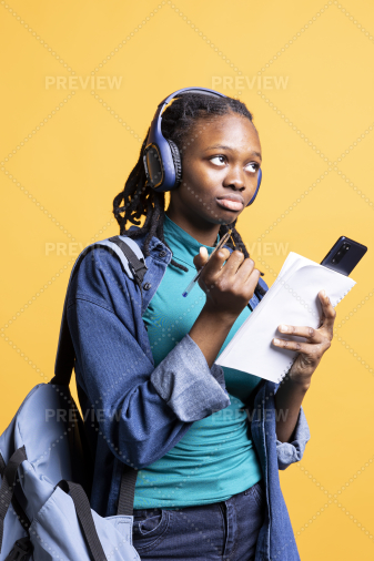 Girl Studying For Exam And Enjoying Songs On Headphones Studio