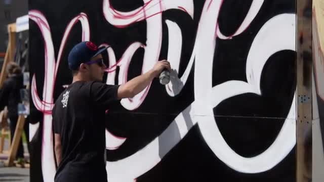 Young Man Drawing Graffiti Text: Stock Video