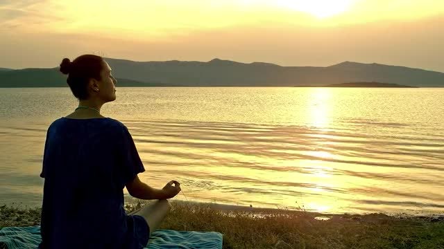 Meditating By A Lake: Stock Video