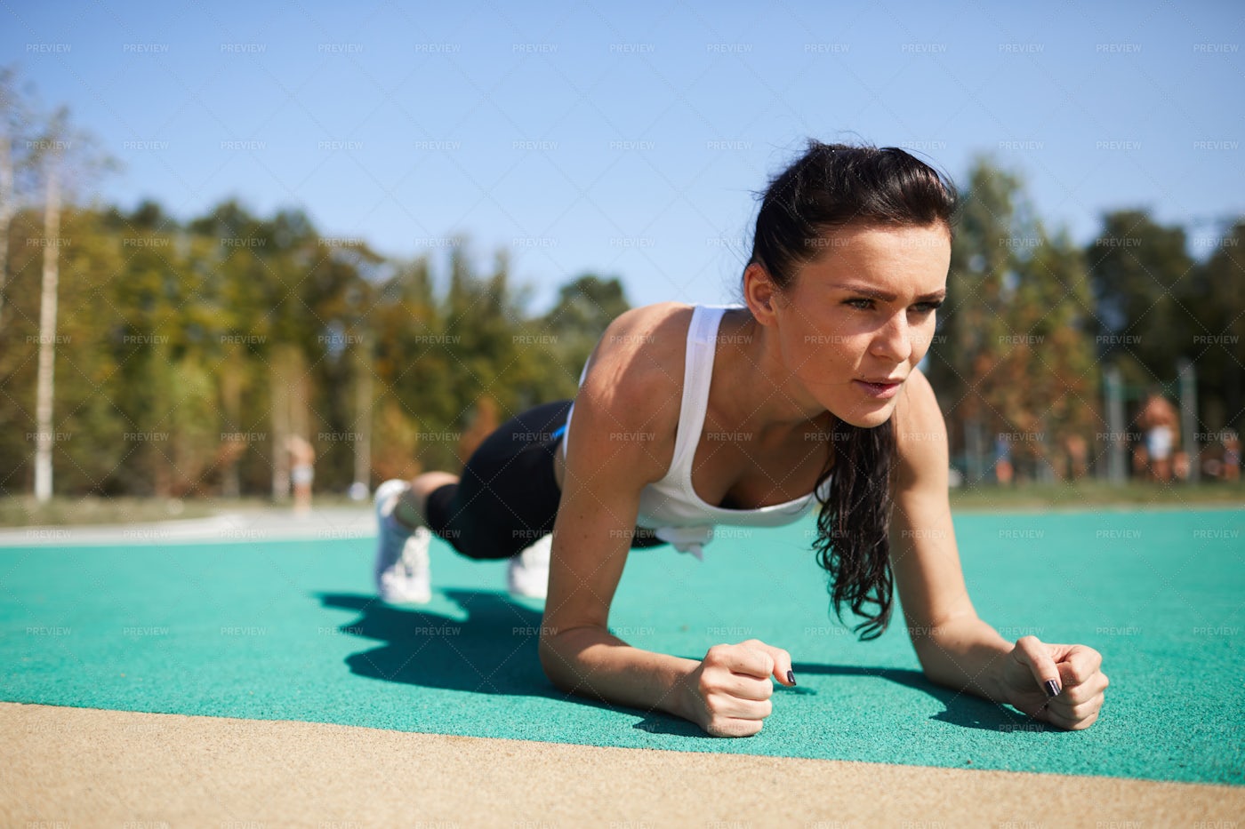 Concentrated Lady Doing Plank At Stadium: Stock Photos